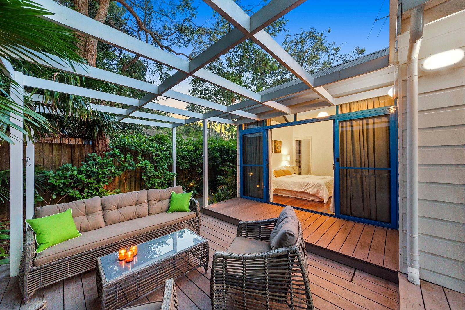 Covered deck at Sails Pearl Beach with outdoor lounge opening to the garden