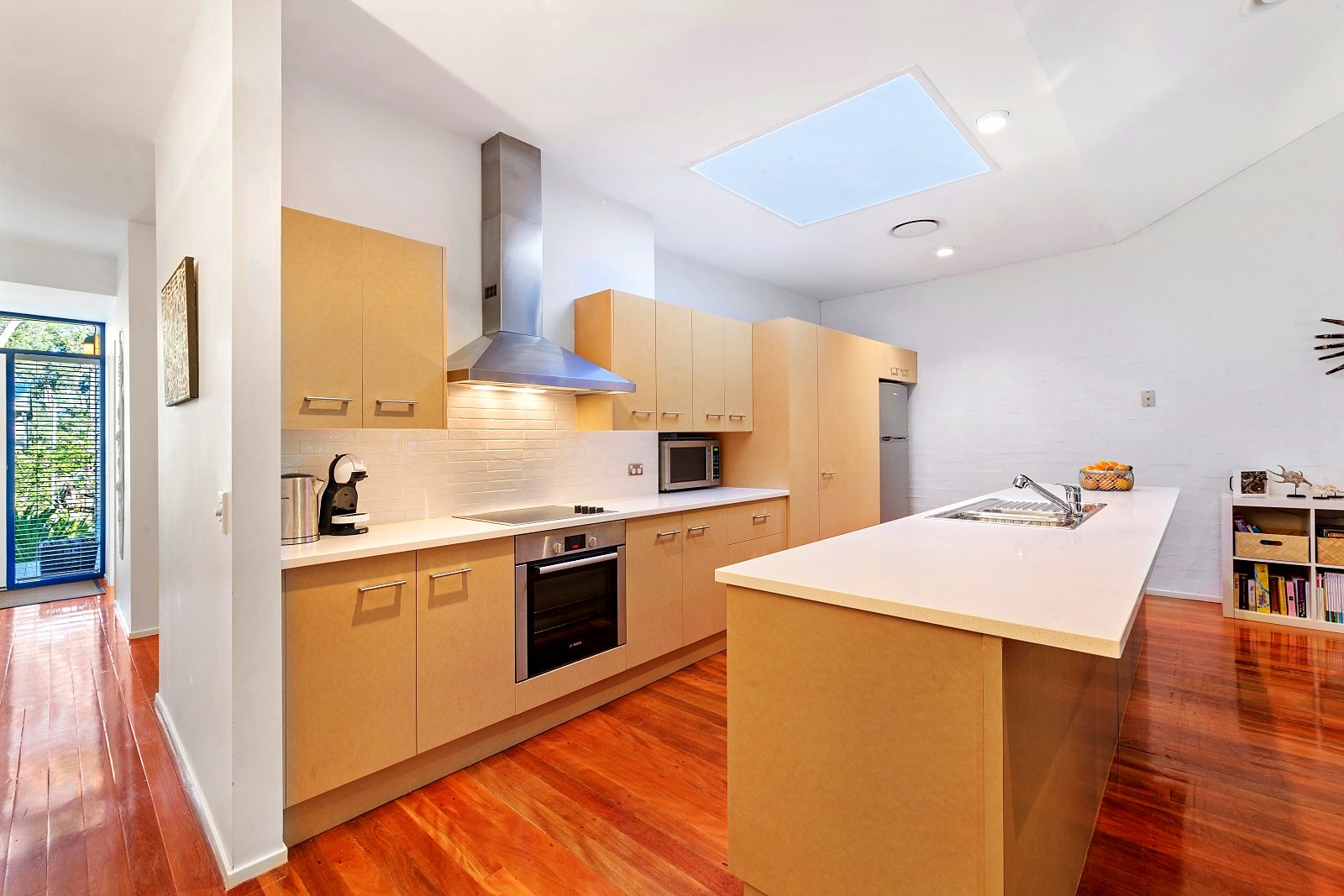 Kitchen at Sails Pearl Beach with timber cabinetry, island bench and skylight