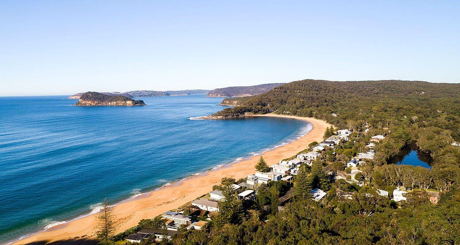 Pearl Beach from above: the curve of sand, Lion Island and Broken Bay
